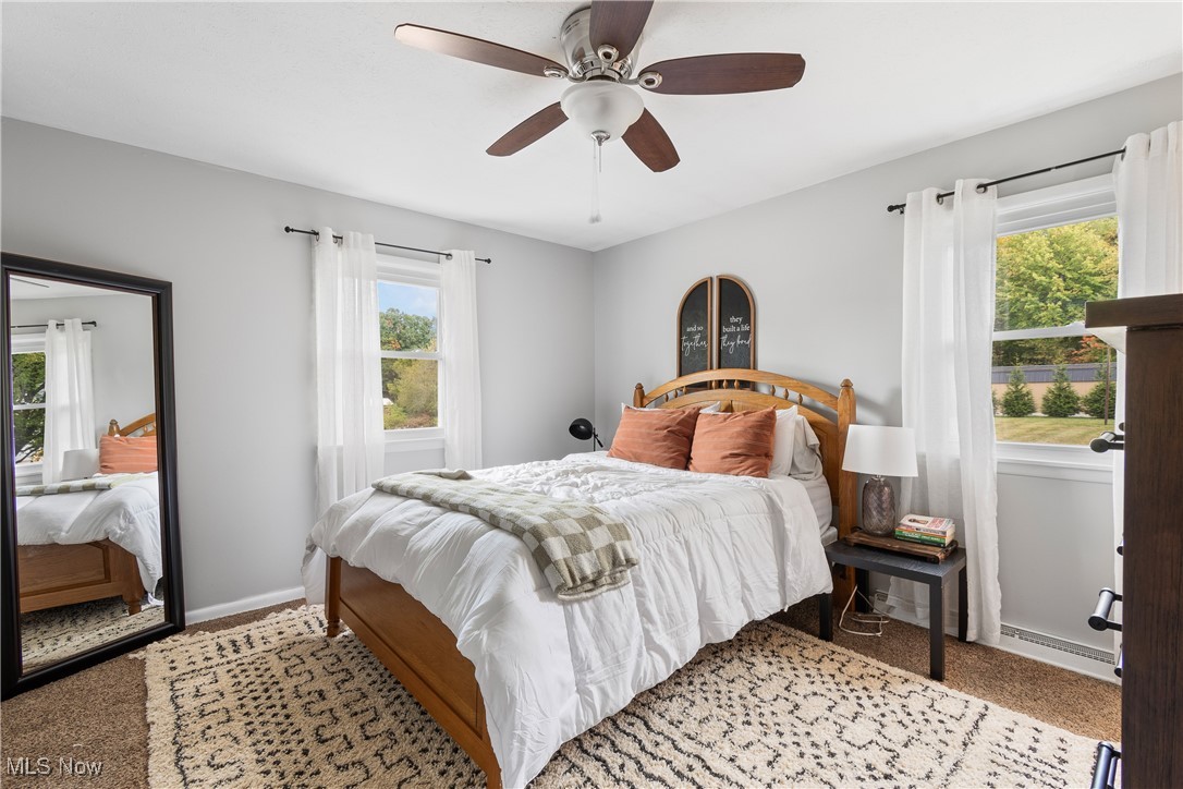 1701 Rheam Road Clinton, OH 44216 - Photo 14 of 31 Carpeted bedroom with a baseboard radiator, multiple windows, and ceiling fan
