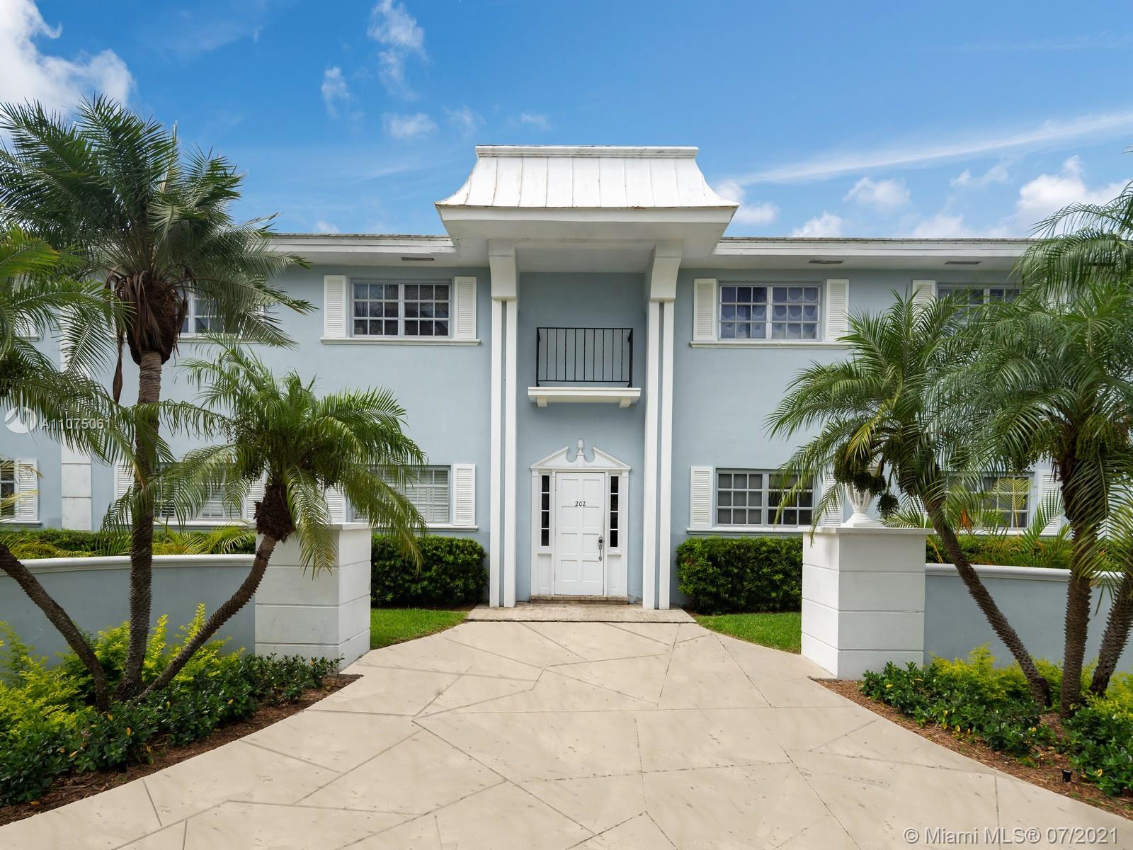 202 Sunrise Drive Key Biscayne, FL 33149 - Photo 3 of 12 a view of a white house with a yard and potted plants