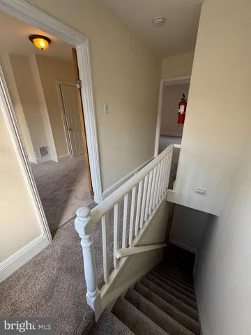a view of a hallway with wooden floor and stairs