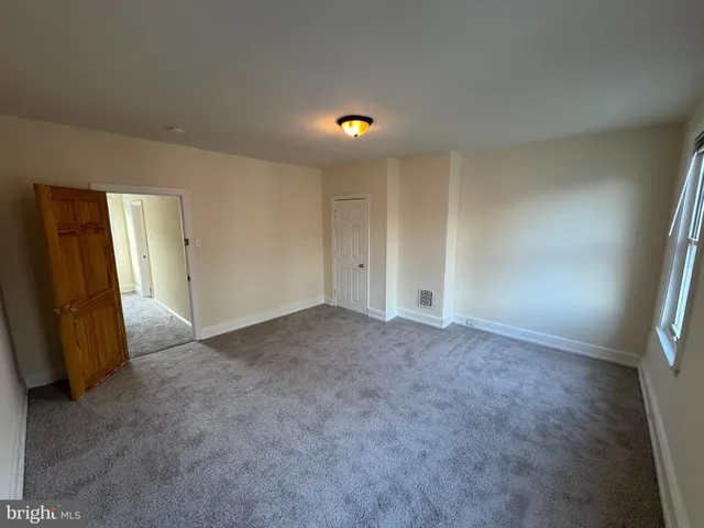 an empty room with closet and mirror