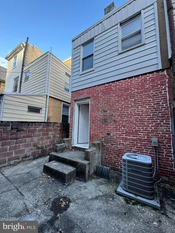a backyard of a house with barbeque oven and glass windows