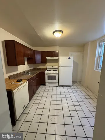 a kitchen with a sink a stove top oven and cabinets