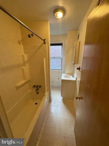 a bathroom with a tub a sink and a shower