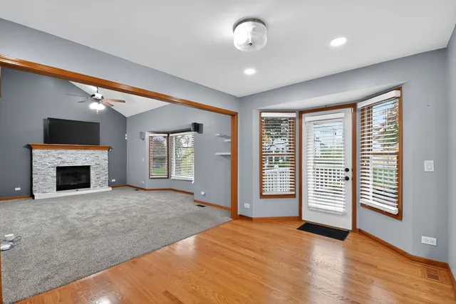 an empty room with windows and fireplace