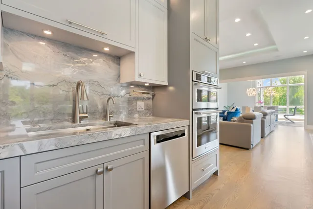 a kitchen with stainless steel appliances granite countertop a sink and a stove top oven