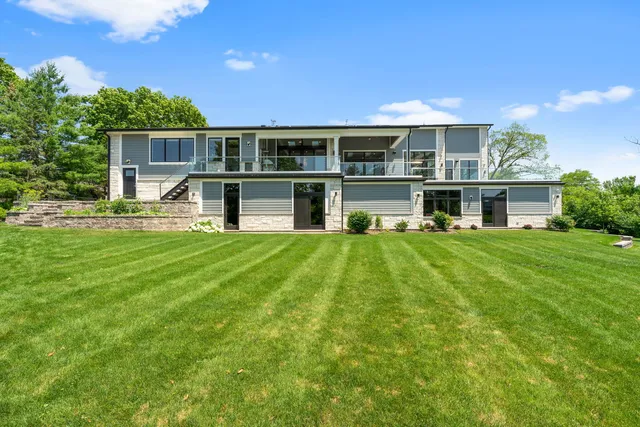a view of house with a big yard and potted plants