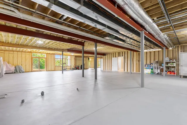 a living room with a large window wooden floor and furniture