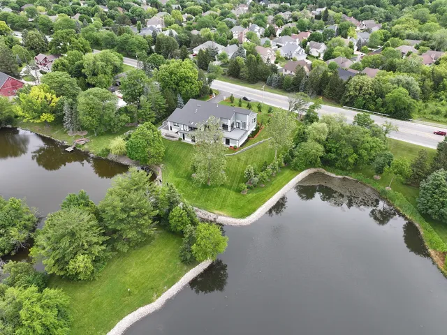 an aerial view of a house with pool and a yard