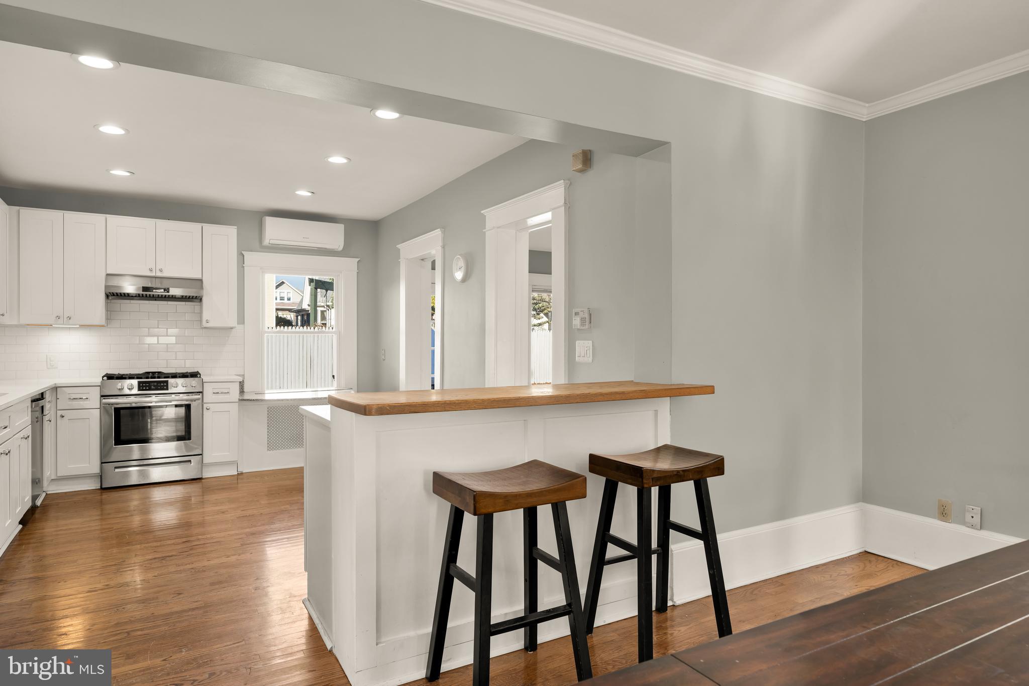 1308 Lawrence Street Northeast Washington, DC 20017 - Photo 13 of 43 a kitchen with stainless steel appliances kitchen island a wooden floor and white cabinets