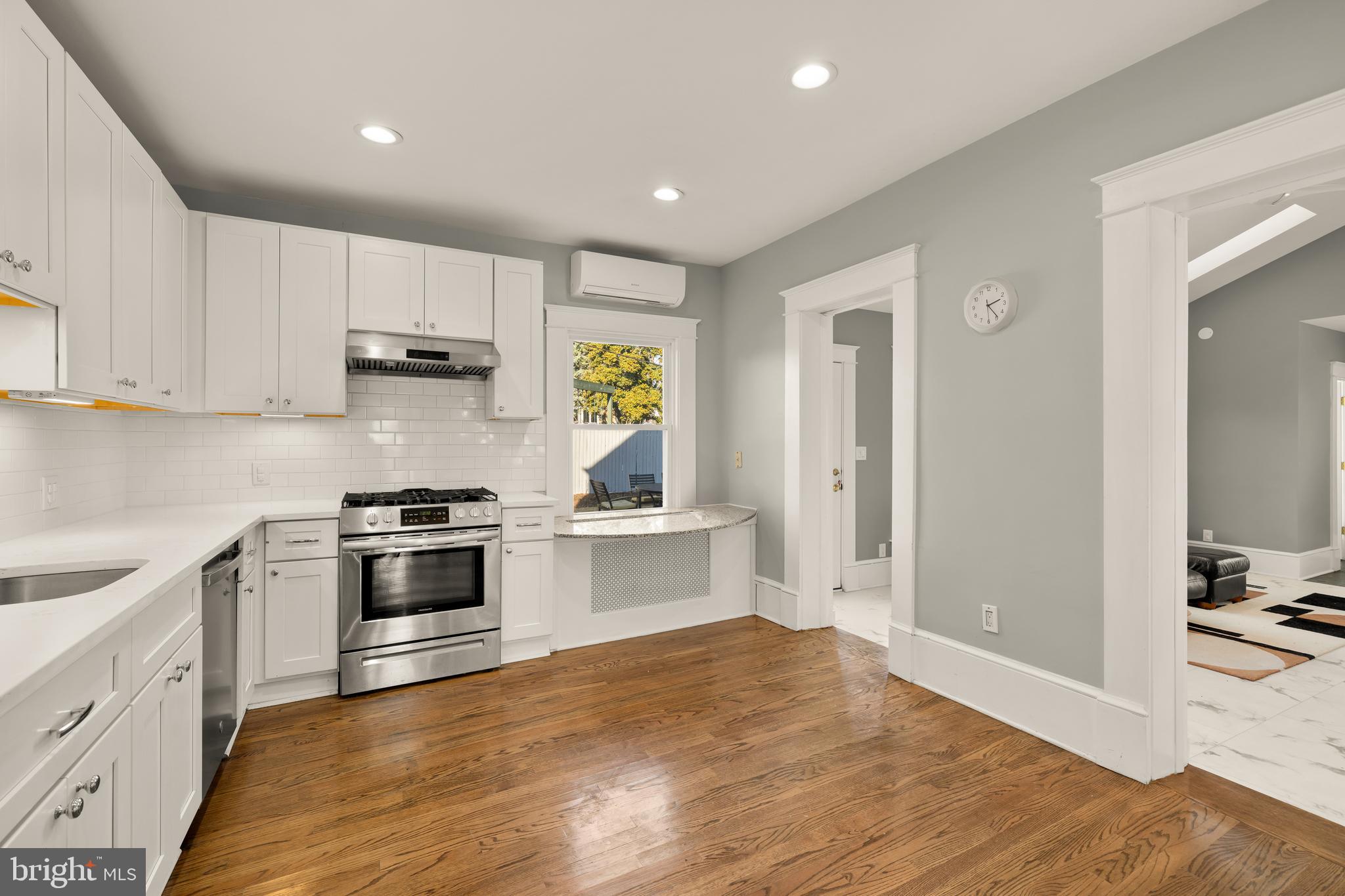1308 Lawrence Street Northeast Washington, DC 20017 - Photo 15 of 43 a kitchen with stainless steel appliances granite countertop a stove top oven a sink a refrigerator and white cabinets with wooden floor