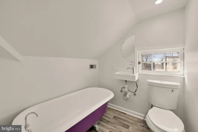 a bathroom with a toilet a sink and mirror