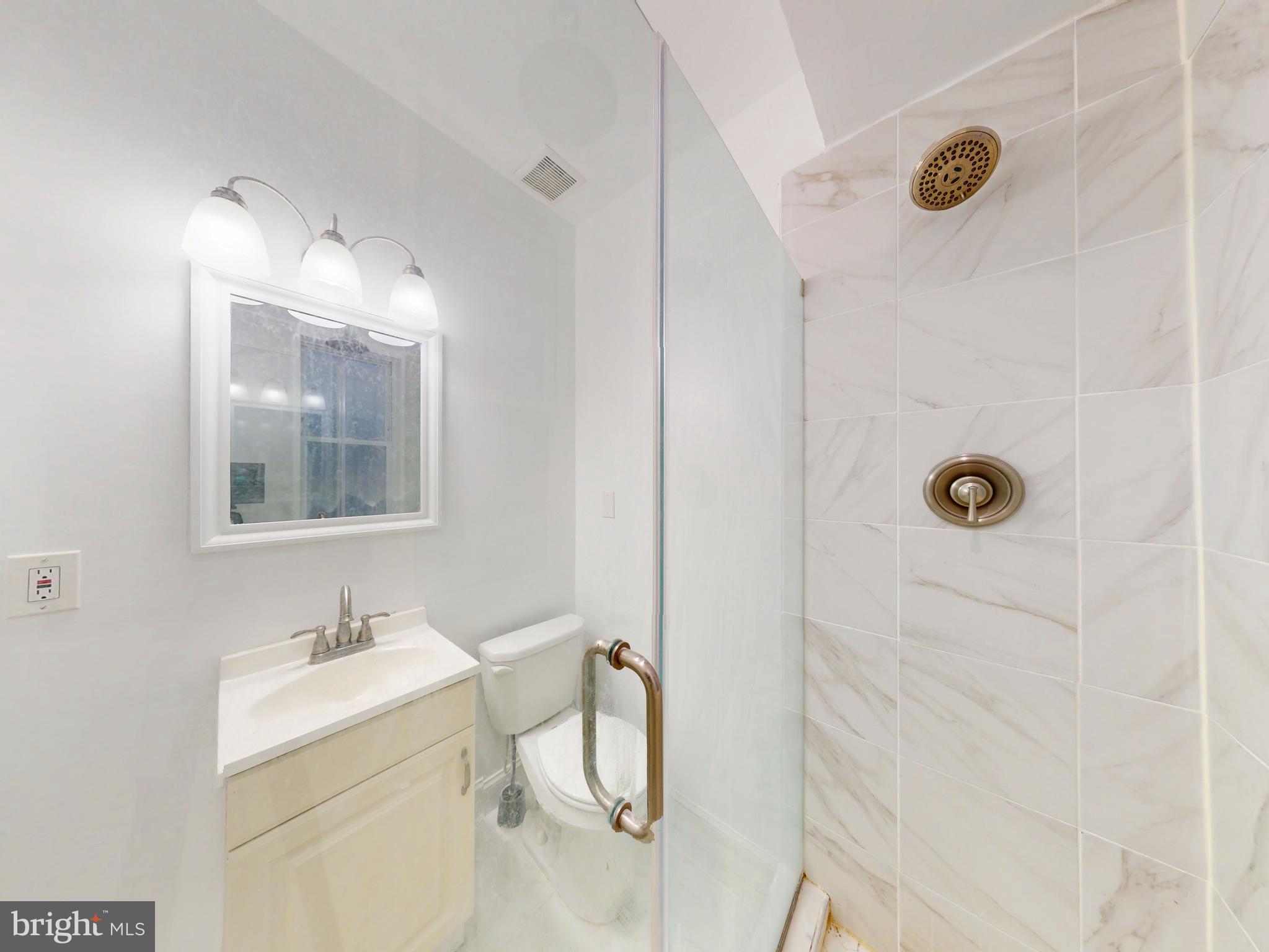 1315 Pennsylvania Ave. Southeast, Unit B Washington, DC 20003 - Photo 5 of 19 a bathroom with a granite countertop sink mirror and vanity