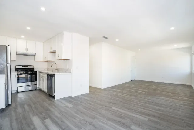 a view of kitchen with granite countertop cabinets and refrigerator