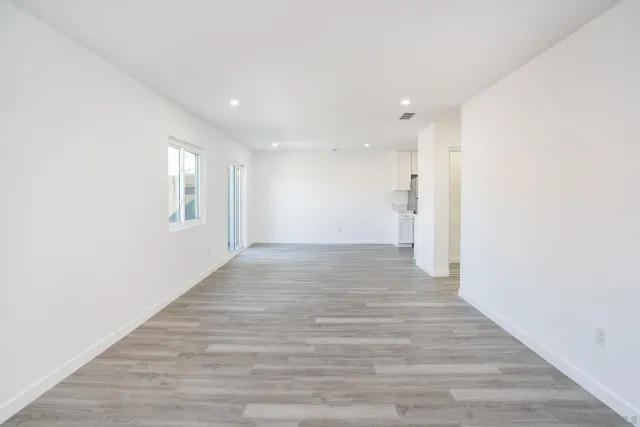 a view of an empty room with wooden floor