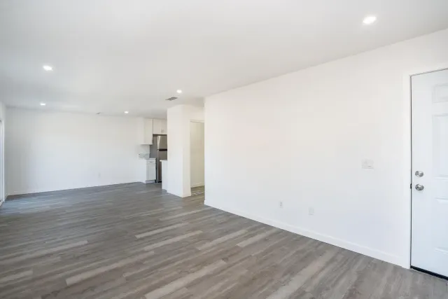 a view of empty room with wooden floor