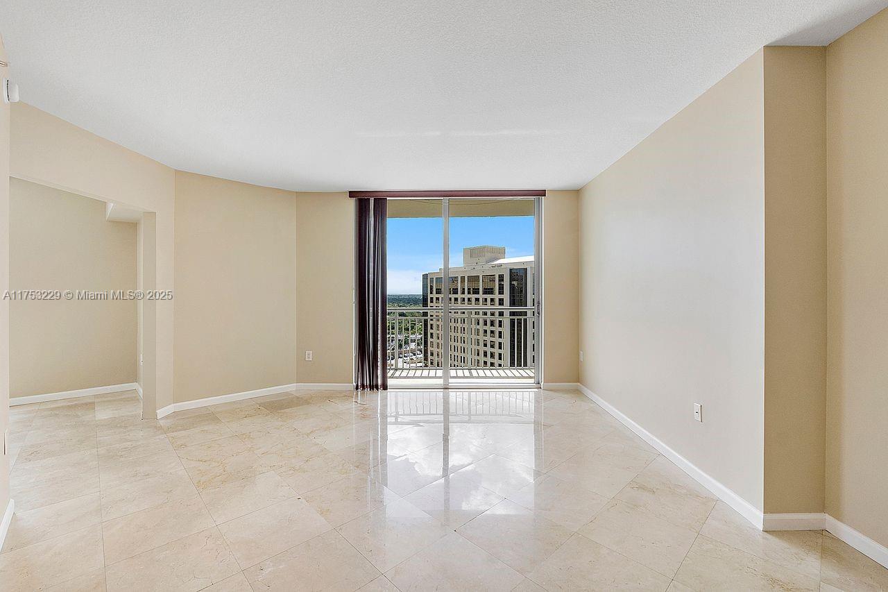 9066 Southwest 73rd Court, Unit 1904 Miami, FL 33156 - Photo 15 of 19 a view of an empty room with wooden floor and a window