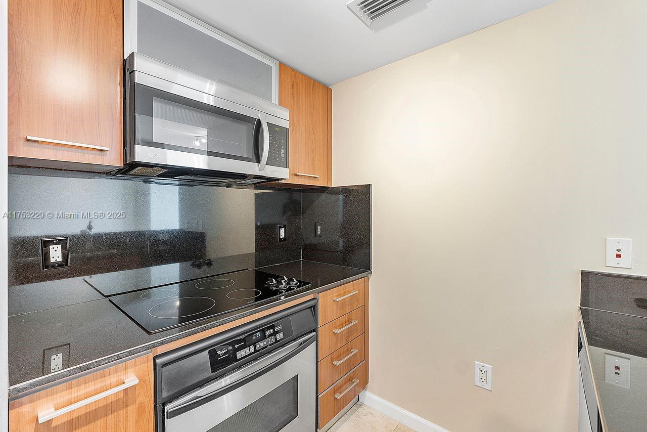 9066 Southwest 73rd Court, Unit 1904 Miami, FL 33156 - Photo 17 of 19 a kitchen with a stove and a microwave