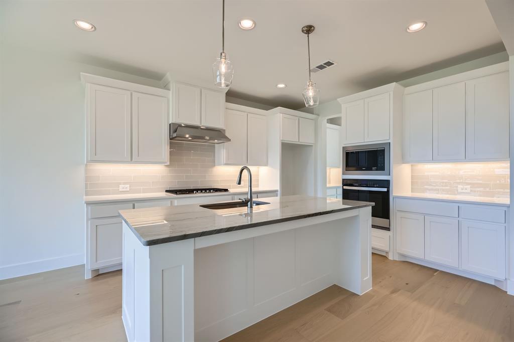 2620 Cedar Rdg Road Celina, TX 75009 - Photo 6 of 27 a kitchen with kitchen island granite countertop a sink cabinets and stainless steel appliances