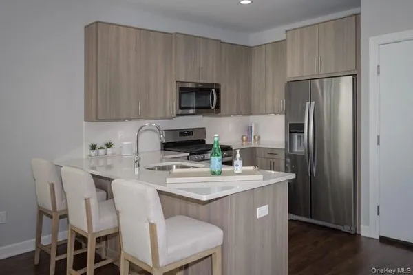 a kitchen with stainless steel appliances granite countertop a sink stove refrigerator and microwave