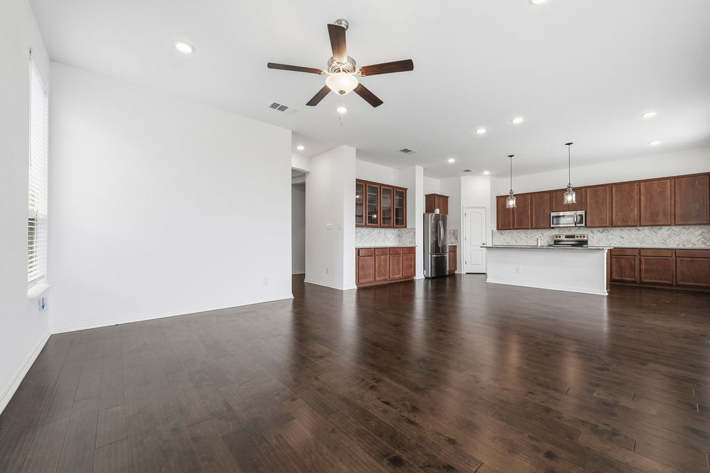 1005 Ridge Runner Drive Georgetown, TX 78628 - Photo 9 of 32 Open-concept living space featuring wood-finish flooring, a ceiling fan with integrated lighting, and recessed ceiling lights
