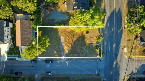 an aerial view of residential houses with outdoor space and trees