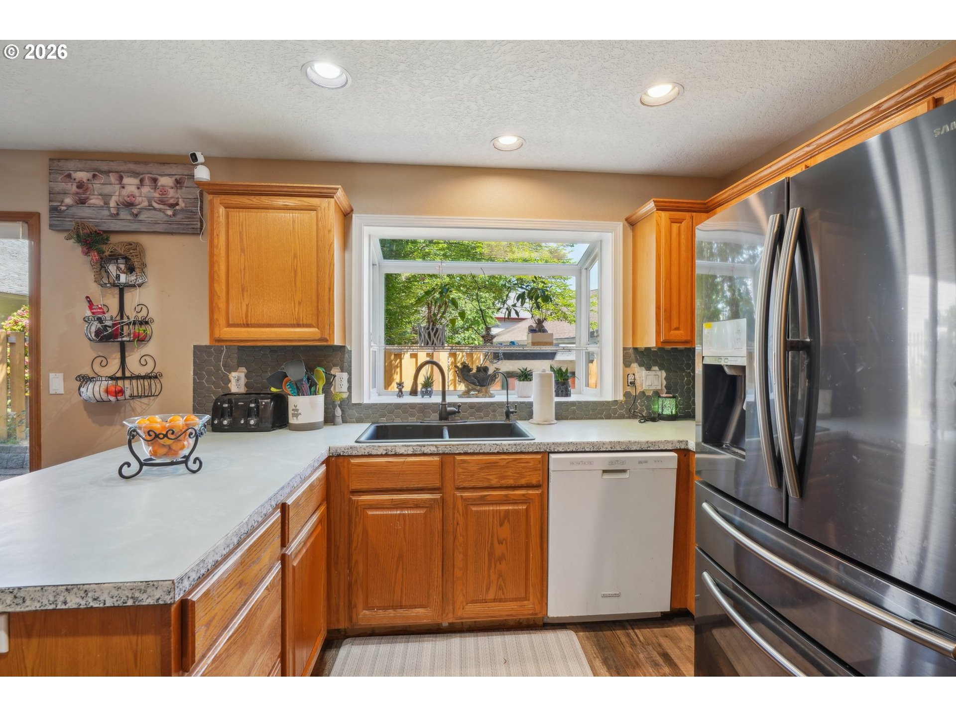4055 Northeast 13th Terrace Gresham, OR 97030 - Photo 11 of 37 a kitchen with stainless steel appliances granite countertop a sink refrigerator and window