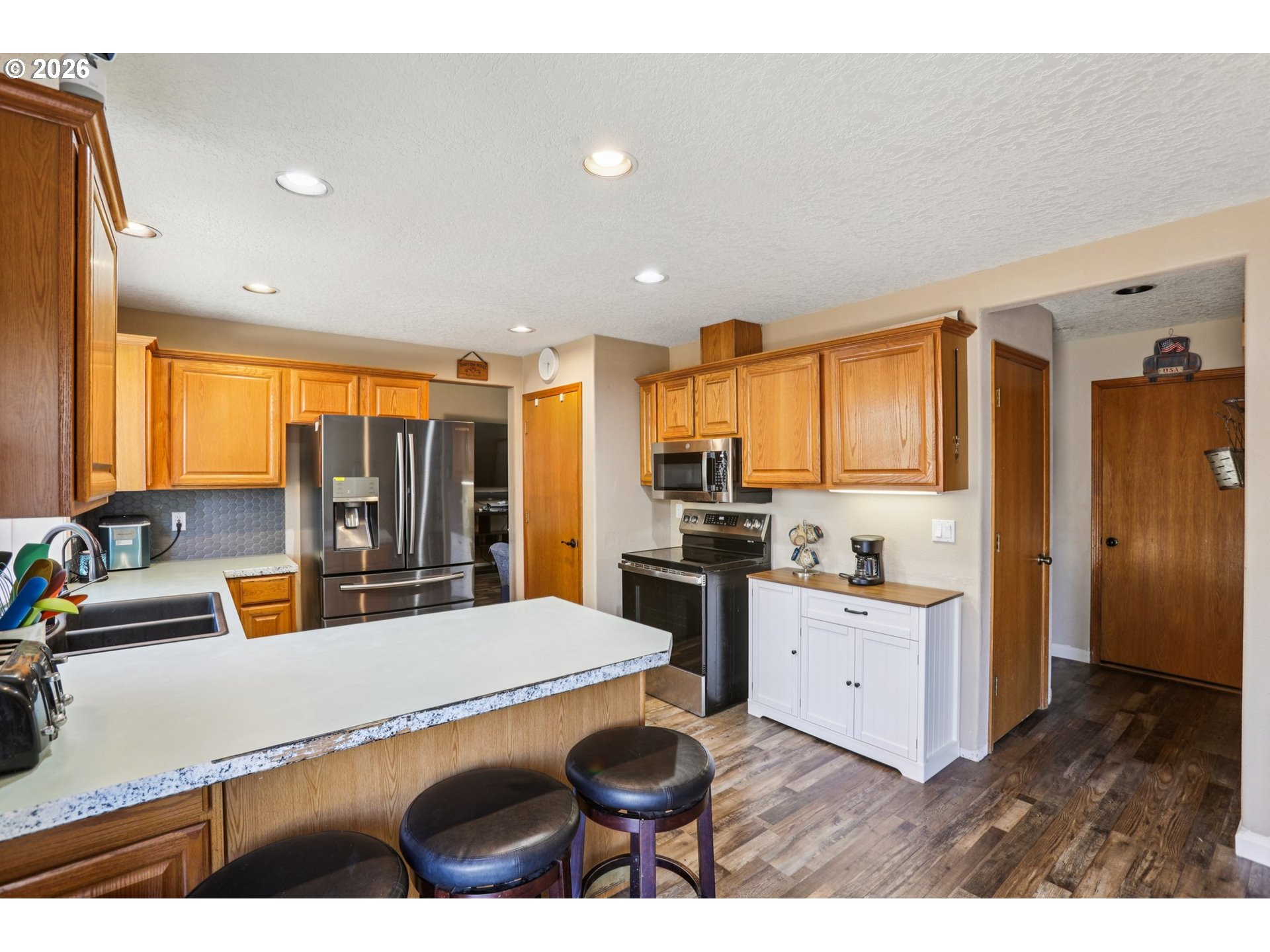 4055 Northeast 13th Terrace Gresham, OR 97030 - Photo 13 of 37 a kitchen with stainless steel appliances kitchen island granite countertop a sink and cabinets