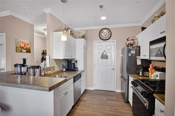a kitchen with granite countertop a stove top oven a sink a counter top space and cabinets
