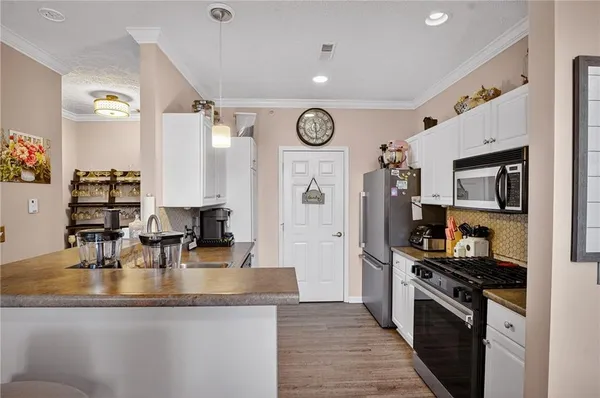 a kitchen with granite countertop a sink a stove top oven and refrigerator