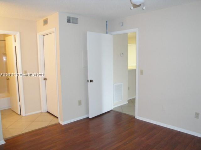 Palm Aire Gardens Condominiums Pompano Beach, FL 33069 - Photo 11 of 14 a view of an empty room with wooden floor and a window