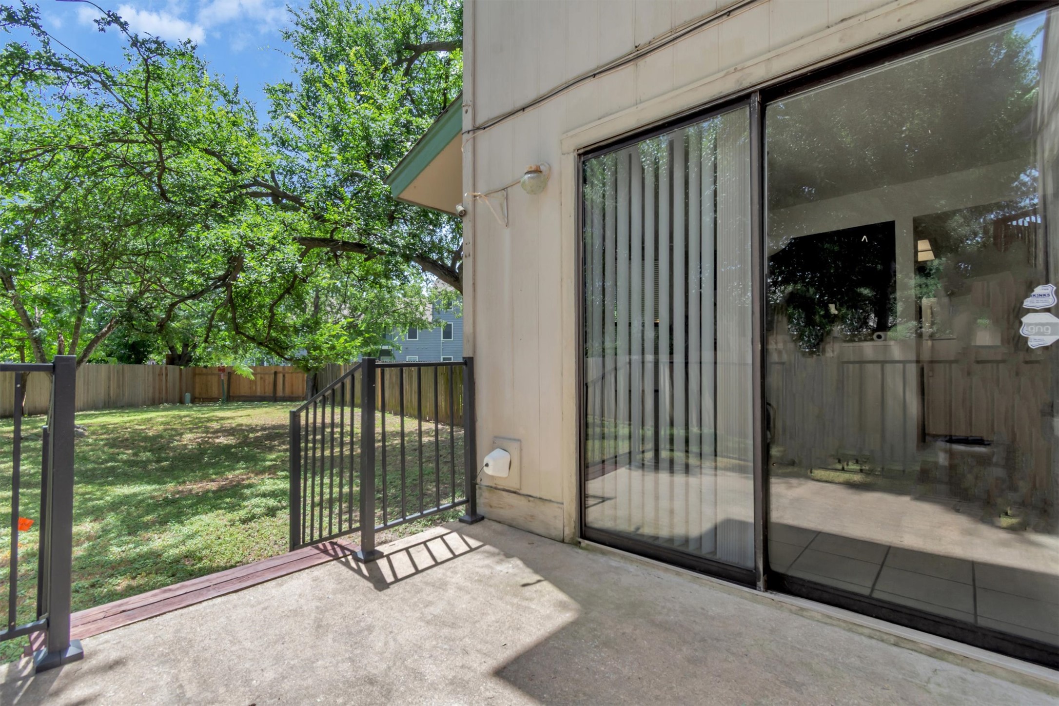 7802 Topawa Cove, Unit B Austin, TX 78729 - Photo 24 of 32 Concrete patio with attractive metal railing overlooks a spacious, fenced rear yard with mature trees.