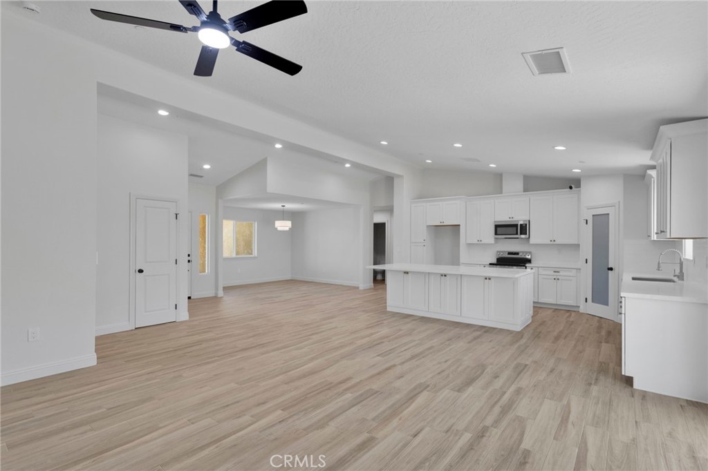 9432 Wasco Hesperia, CA 92345 - Photo 14 of 45 a large white kitchen with kitchen island a sink stainless steel appliances and cabinets
