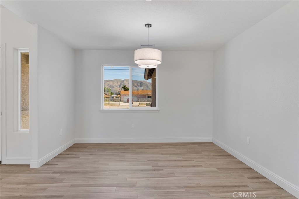 9432 Wasco Hesperia, CA 92345 - Photo 16 of 45 a view of an empty room with wooden floor and a window