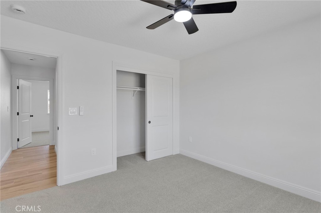 9432 Wasco Hesperia, CA 92345 - Photo 33 of 45 an empty room with a ceiling fan and carpet
