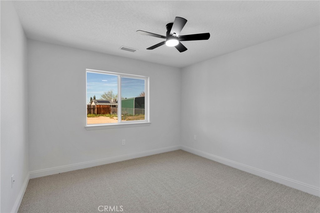 9432 Wasco Hesperia, CA 92345 - Photo 36 of 45 an empty room with a window and a ceiling fan