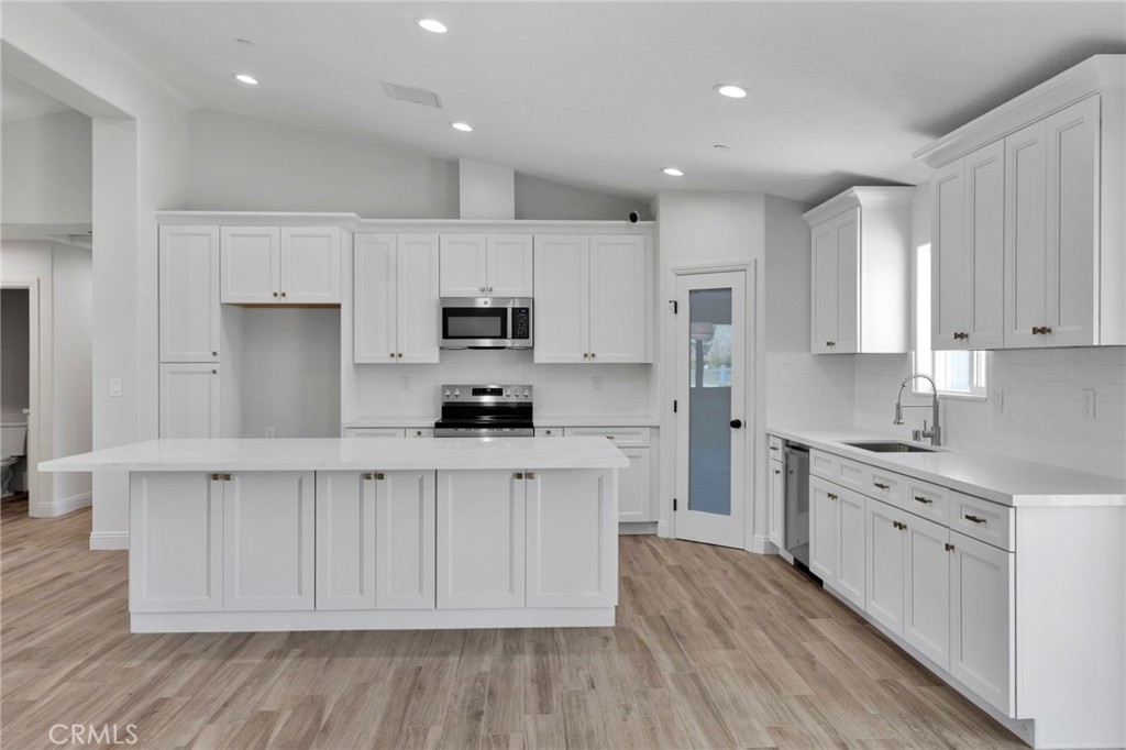 9432 Wasco Hesperia, CA 92345 - Photo 6 of 45 a kitchen with stainless steel appliances granite countertop a stove a sink and white cabinets