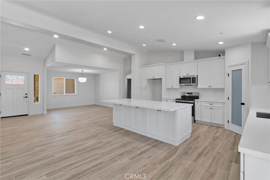 9432 Wasco Hesperia, CA 92345 - Photo 7 of 45 a large white kitchen with kitchen island a sink wooden floor and stainless steel appliances
