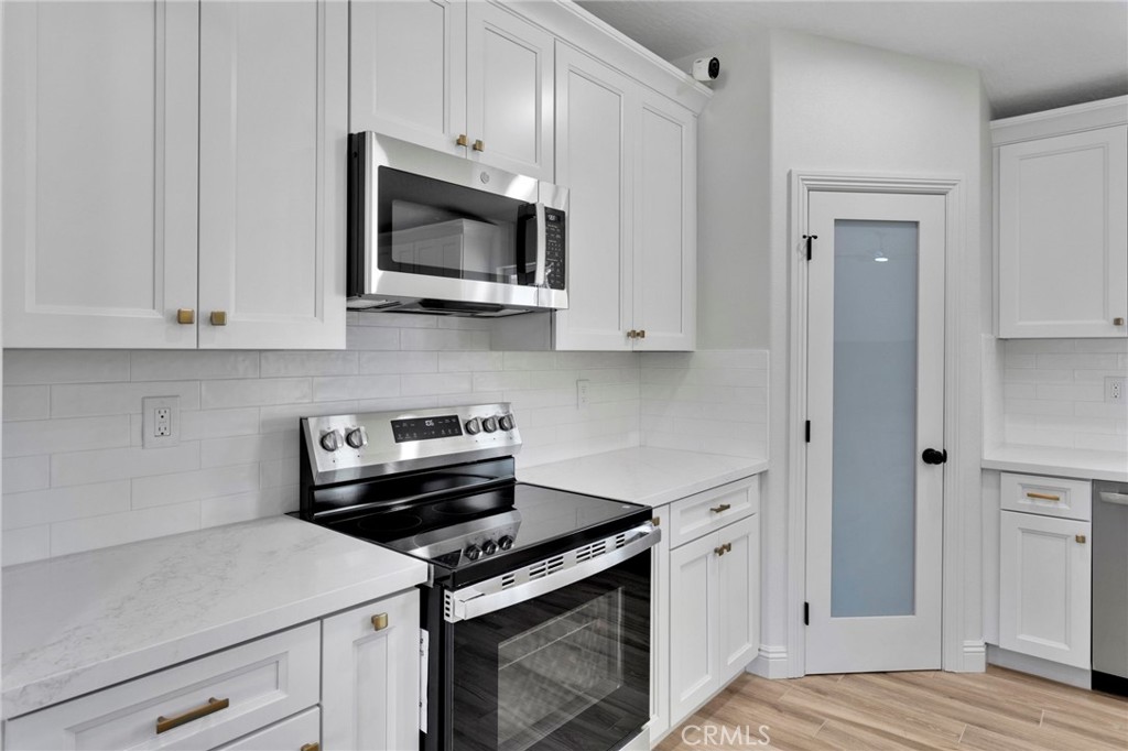 9432 Wasco Hesperia, CA 92345 - Photo 9 of 45 a kitchen with white cabinets and stainless steel appliances