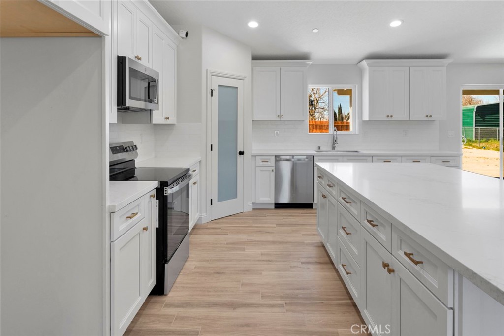 9432 Wasco Hesperia, CA 92345 - Photo 10 of 45 a kitchen with stainless steel appliances a sink stove refrigerator and cabinets