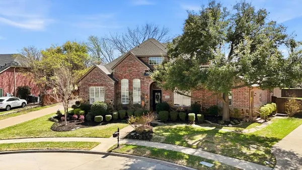 a front view of a house with a yard outdoor seating and covered with trees