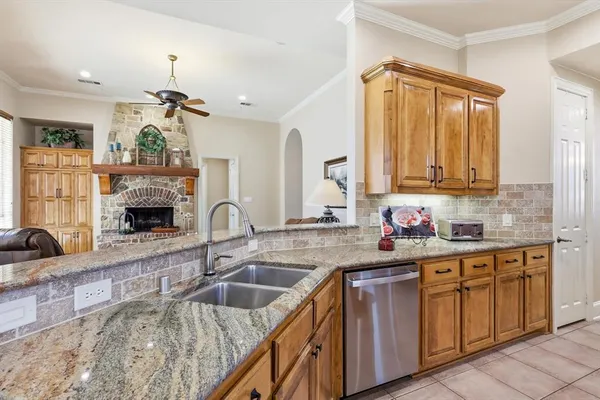 a kitchen with stainless steel appliances granite countertop wooden cabinets a center island and a window