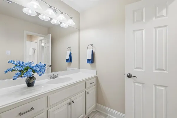 a kitchen with stainless steel appliances granite countertop a stove top oven a sink dishwasher and white cabinets with wooden floor