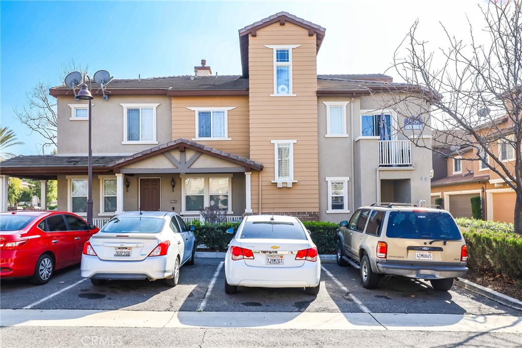 a front view of a house with cars parked