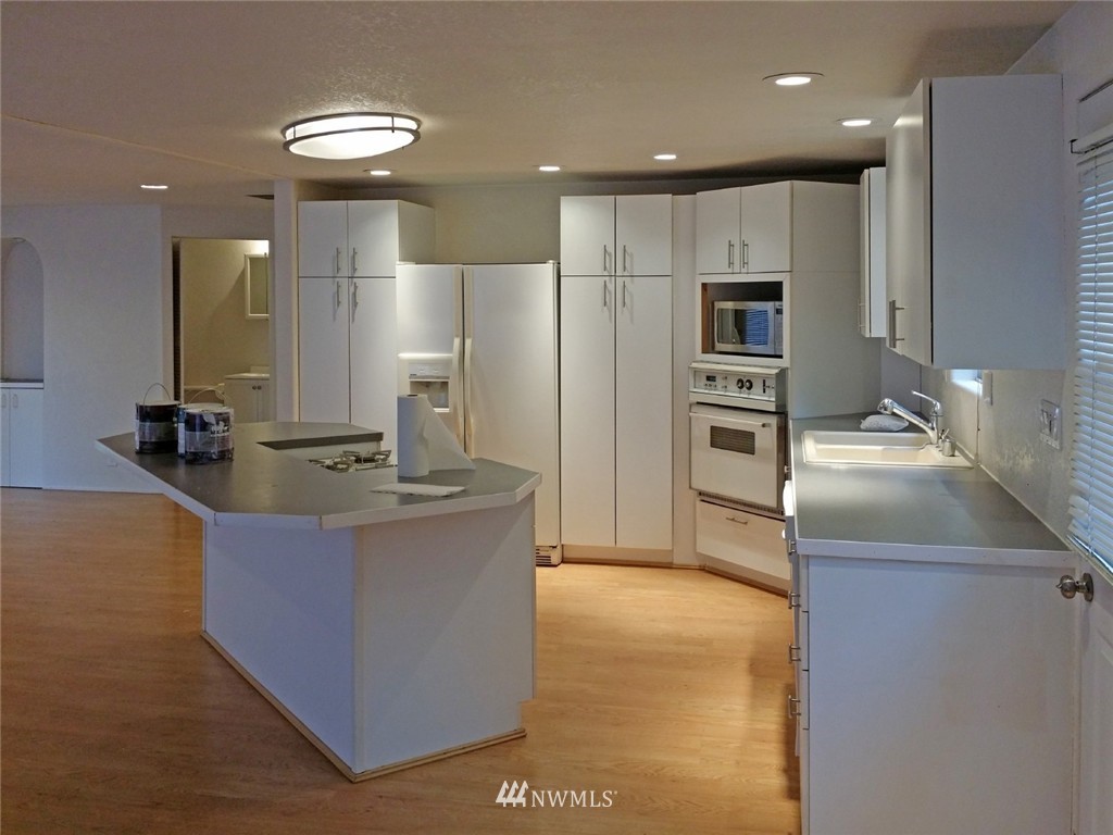 19007 126th Avenue Northeast Bothell, WA 98011 - Photo 5 of 15 a kitchen with stainless steel appliances granite countertop a sink a stove and a refrigerator