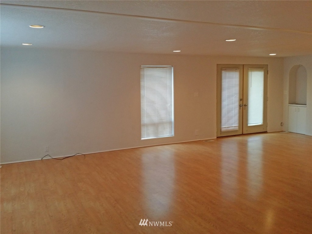19007 126th Avenue Northeast Bothell, WA 98011 - Photo 6 of 15 an empty room with wooden floor and windows