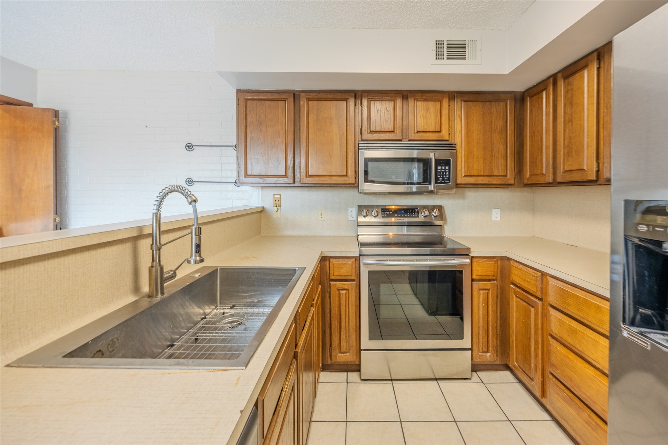2002 South Lubbock Street Brenham, TX 77833 - Photo 4 of 26 a kitchen with granite countertop a stove a sink and a microwave