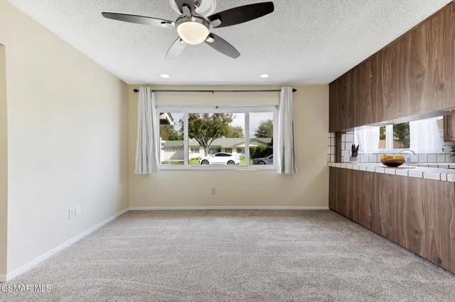 a view of a kitchen with refrigerator and ceiling fan