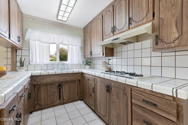 a kitchen with a stove and a wooden cabinets