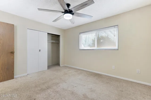 an empty room with fan and windows