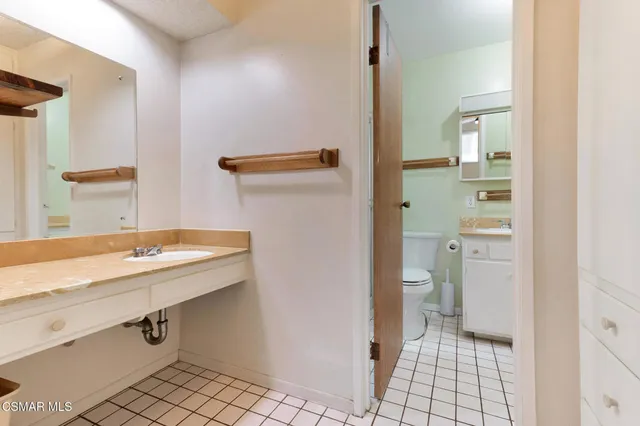 a bathroom with a sink a toilet and mirror